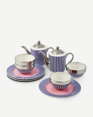 Blue and white striped porcelain tea set with pink accents, including two teapots, two teacups, and matching saucers on a white surface.