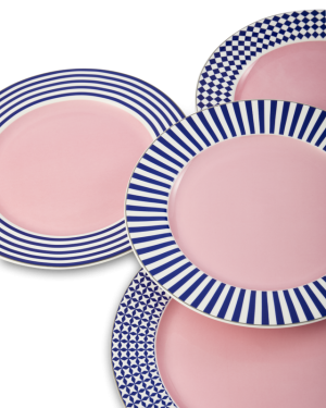 Cluster of pink ceramic plates with blue striped rims overlapping against a black background.