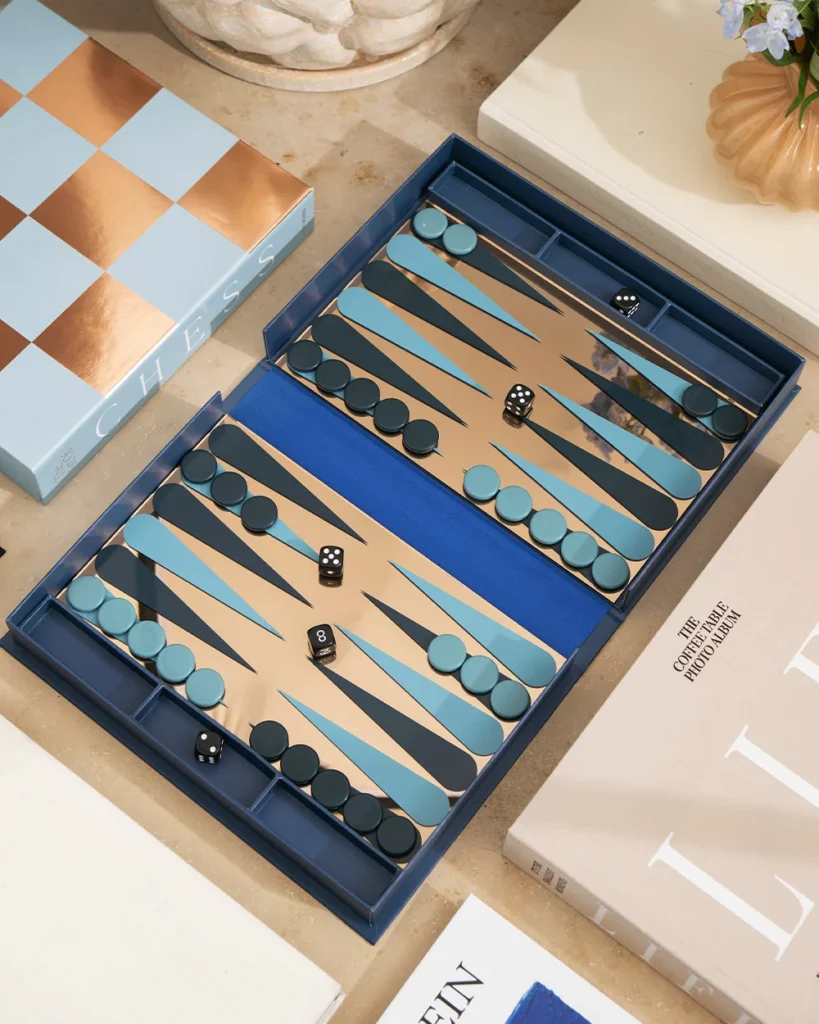 Backgammon board open on a table with blue and teal playing pieces and dice in play.