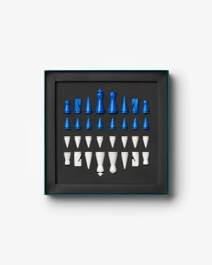 Boxed set of blue and white chess pieces arranged in rows on a black tray inside a dark box, viewed from above