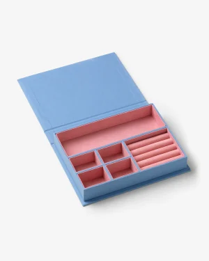 Open blue jewelry organizer with pink interior and multiple compartments for rings, earrings, and bracelets.