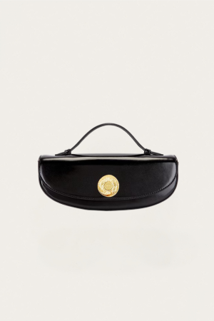 Black leather handbag with a gold circular clasp on a pale background, centered in the image.