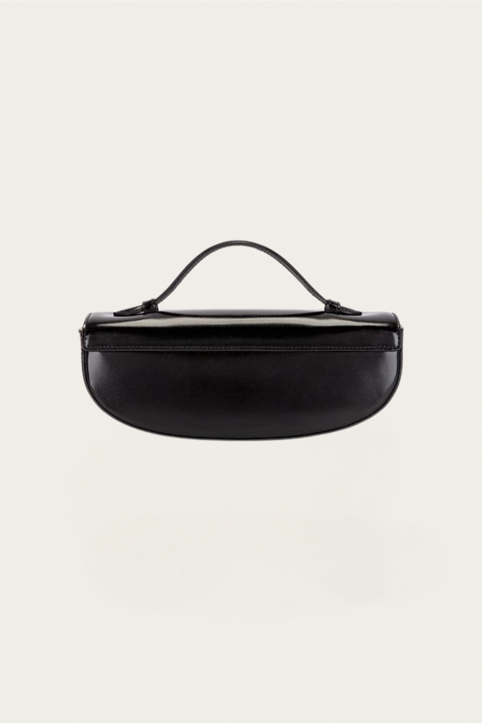 Black patent-leather clutch with a curved, short handle on a light background, centered in frame.