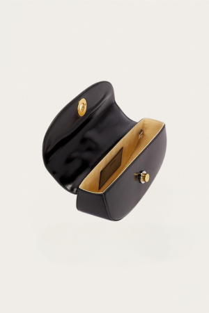 Open black leather handbag with tan interior and gold hardware visible (turn-lock clasp)