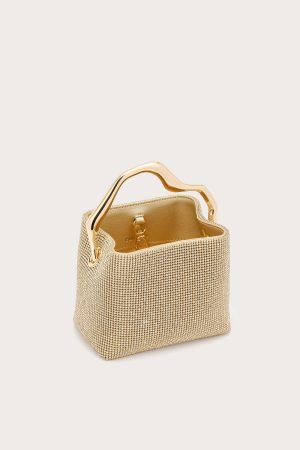 Gold mesh handbag with a curvy gold handle against a pale background.