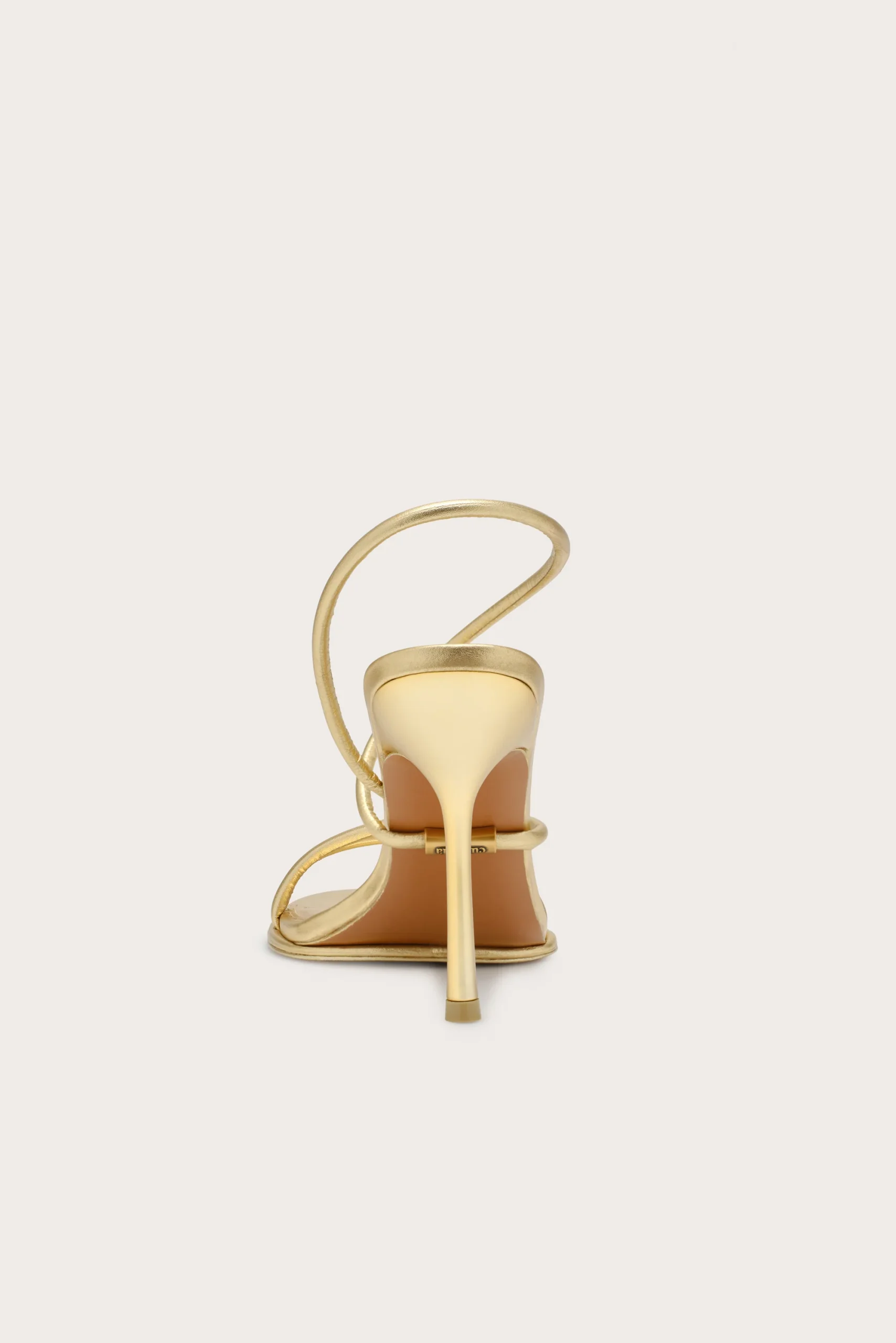 IMG_2613 - New Trend Back view of a gold strappy high-heeled sandal with a curved ankle strap, open back, and slender stiletto heel.