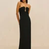 IMG_2619 - New Trend Full-length portrait of a woman in a black strapless gown with gold leaf accents at the bust against a beige backdrop.
