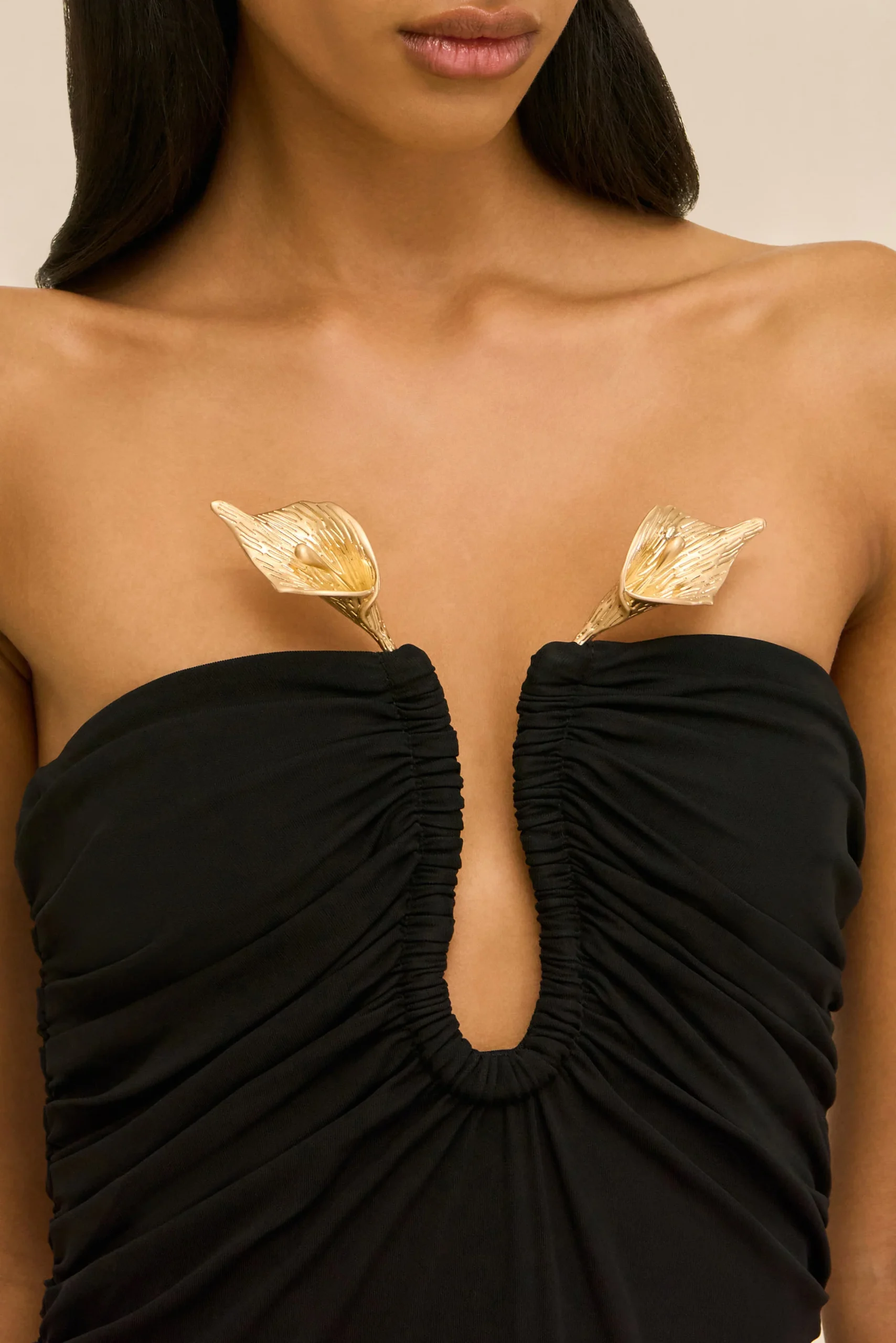 IMG_2620 - New Trend Close-up of a woman wearing a black strapless outfit with gold leaf pasties over the chest area.
