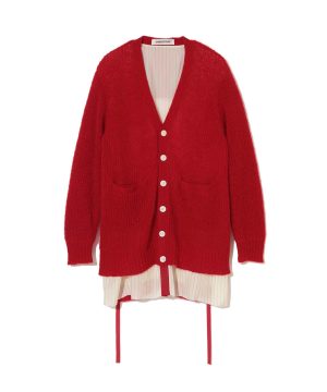 Red chunky knit cardigan with white buttons worn over a cream pinstriped dress, featuring two front pockets and long ties visible at the hem.