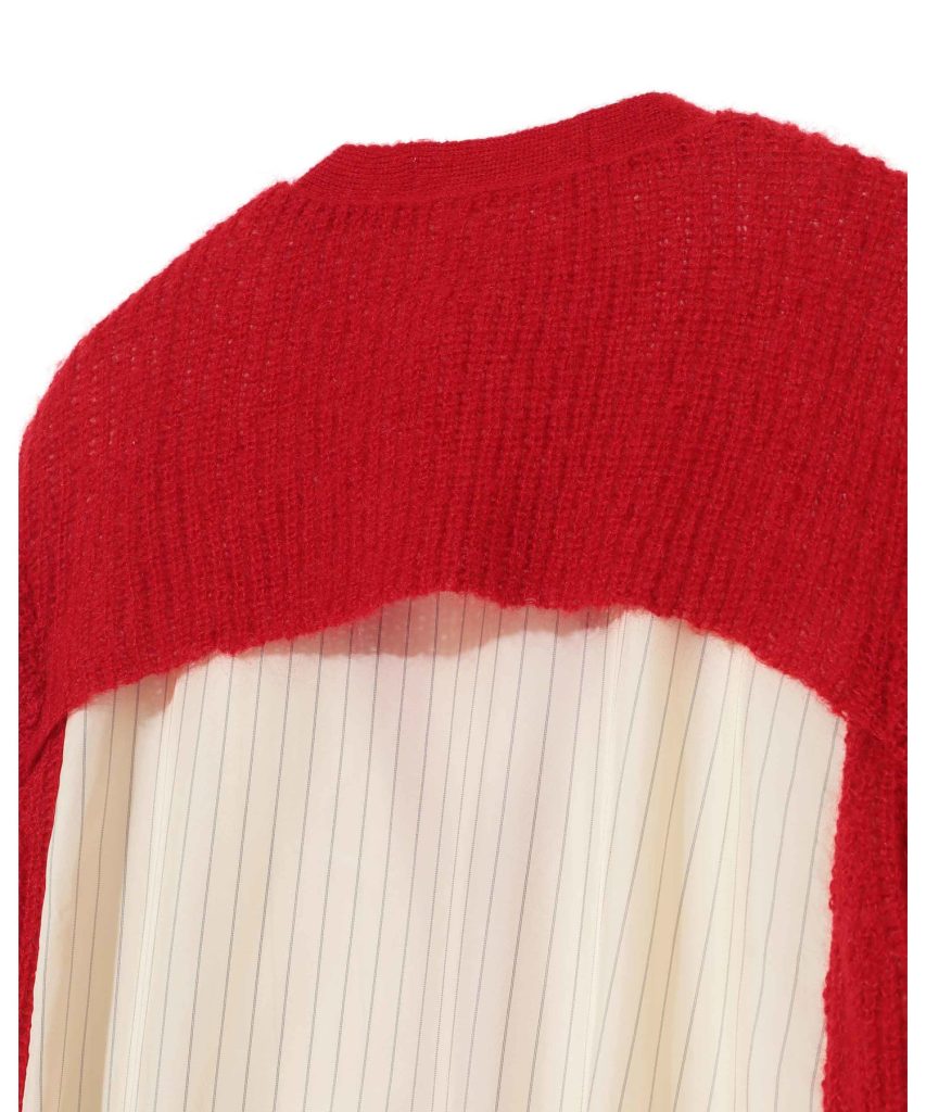 Close-up of a red knitted sweater layered over a white striped shirt, showing the neckline area.