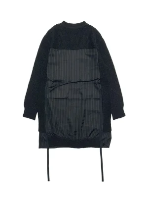 Back view of a black textured knit coat with a padded pinstripe panel down the back