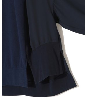 Close-up of dark navy fabric with visible seam and layered hems, suggesting a clothing garment edge.