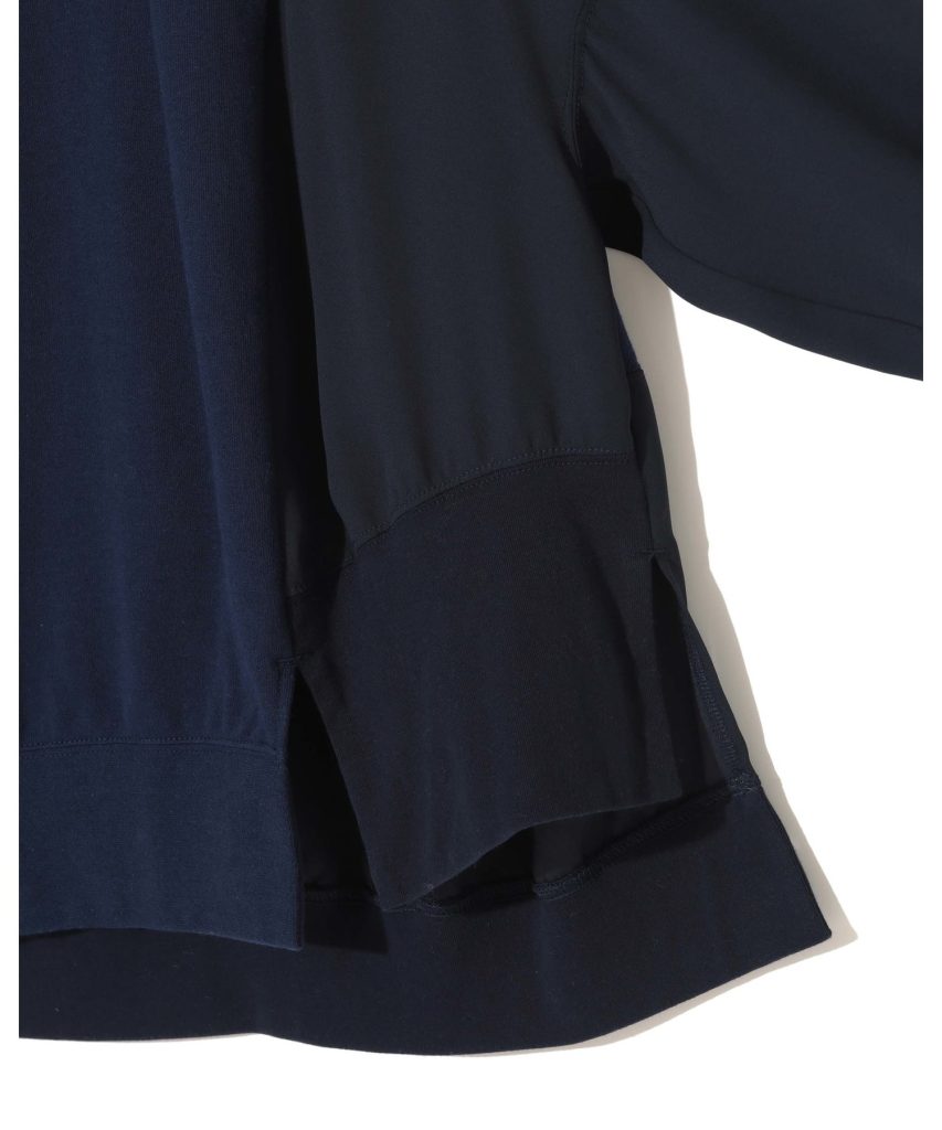 Close-up of dark navy fabric with visible seam and layered hems, suggesting a clothing garment edge.