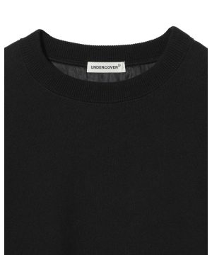 Close-up of a black crewneck neckline with a white 'UNDERCOVER' brand tag sewn inside