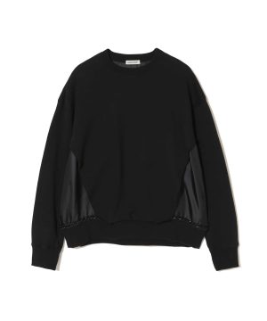 Black crewneck sweatshirt with ribbed cuffs and glossy side panels along the sleeves, small white UNDERCOVER label at the neck.