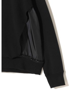 Close-up of a black jacket interior showing satin lining pocket and stitched edges near the hem.