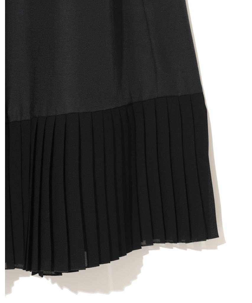 Black fabric with a pleated hem, likely a pleated skirt or dress edge.