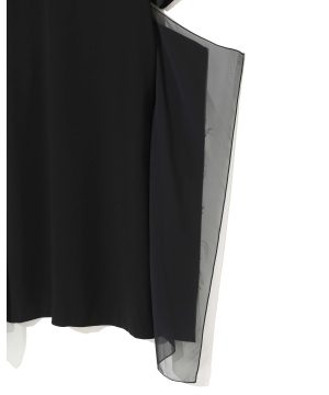 Close-up of a black garment with a sheer gray overlay along the right edge. The contrast shows a layered fabric detail.