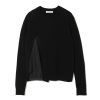 Black knit sweater with a hidden striped lining on the left side and a white brand tag (Undercover) at the neckline edge.