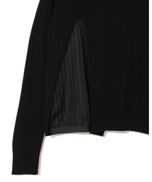 Close-up of a black knit sweater with a striped lining visible at the sleeve opening.