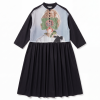 Black dress with a pale blue bodice featuring a portrait print overlaid by green lace, and a gathered waist.