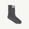 Pair of dark gray ribbed socks with a white label tag on the cuff, laid flat against a light background.