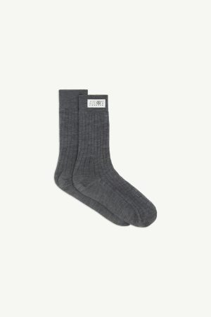 Pair of dark gray ribbed socks with a white label tag on the cuff, laid flat against a light background.