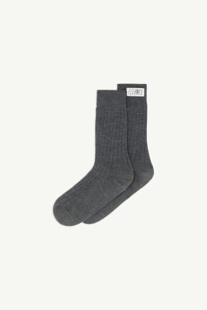 Pair of dark gray ribbed socks laid flat on a light background with a small white size tag at the cuff edge
