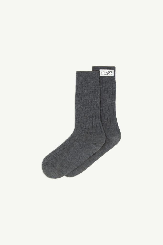 Pair of dark gray ribbed socks laid flat on a light background with a small white size tag at the cuff edge