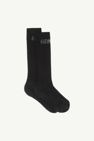 Pair of black socks with small white printed numbers near the cuff (top).