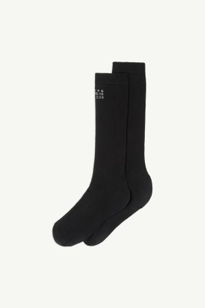 Pair of black crew socks with white logo/text on the upper cuff, shown against a light background