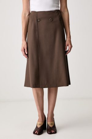 Brown midi A-line skirt with a double-button front detail, paired with a white top and brown open-toe heels.