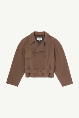 Brown cropped trench coat with a belted waist, wide lapels, and double-breasted buttons, shown from the chest up against a pale background.