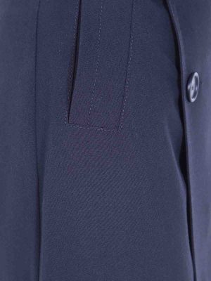 Close-up of a navy blazer showing a pocket flap and a dark button.