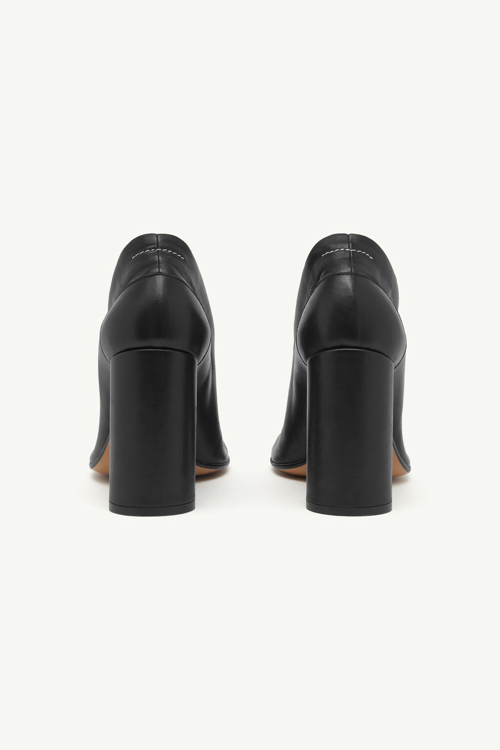 IMG_2966 - New Trend Pair of black leather block-heeled pumps shown from the back, highlighting the chunky heels and stitching detail on the upper.