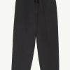 Black drawstring-waist pants with a relaxed fit, shown from the waist to calves.