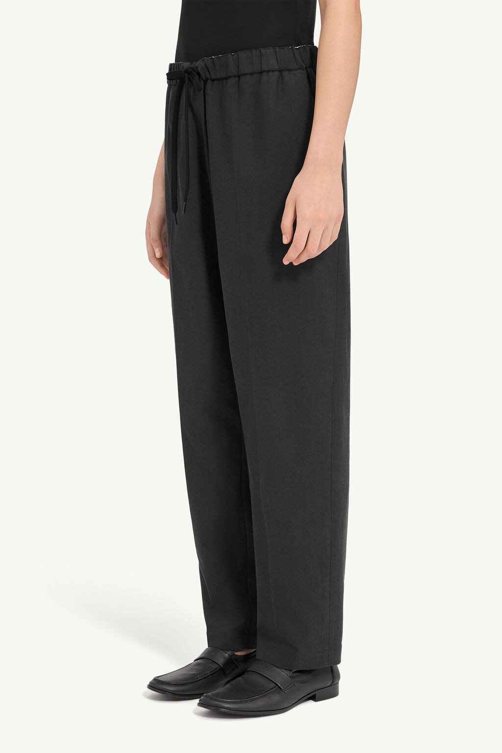 IMG_2973 - New Trend Black wide-leg pants with an elastic drawstring waist, shown with a black top and black loafers (side view).