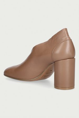 Brown leather pump with a chunky block heel and visible top-stitch seam at the back, shown from a side angle.