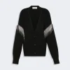 Waist-length black knit cardigan with a deep V-neck and silver fringe detailing along the sleeves, button-down front.