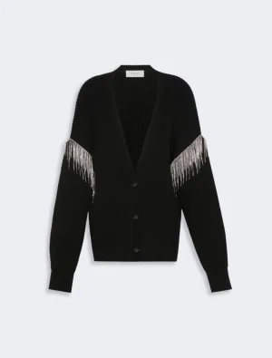 Waist-length black knit cardigan with a deep V-neck and silver fringe detailing along the sleeves, button-down front.