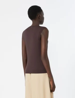 Back view of a person wearing a brown sleeveless knit top and beige skirt