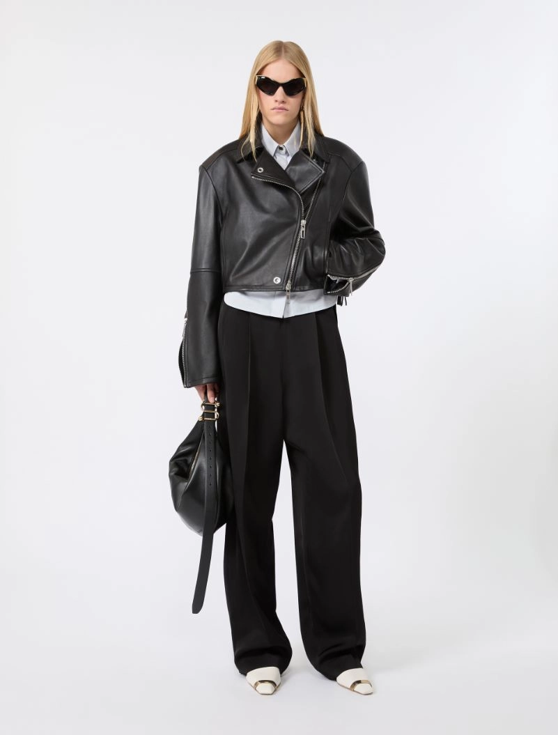 IMG_3047 - New Trend Model in a cropped black leather jacket, white shirt, and wide-leg black trousers with dark sunglasses and a black handbag.