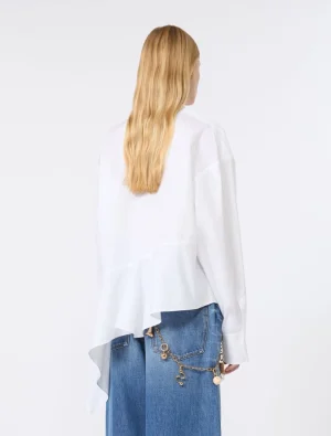 Back view of a person with long blonde hair wearing a white asymmetrical blouse and blue denim jeans with a gold chain accessory on the pocket area?