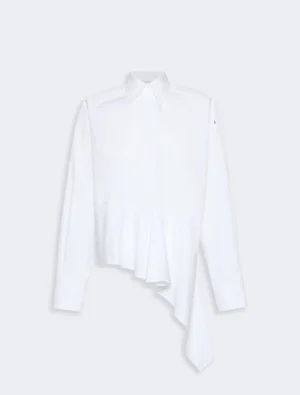 White button-down shirt with an asymmetric, draped hem and long sleeves, standalone on a light gray background