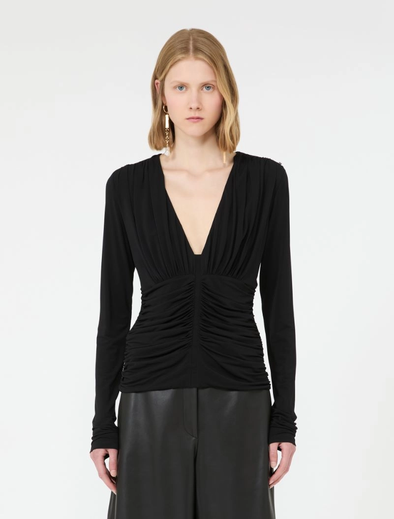IMG_3072 - New Trend Model wearing a black deep-V ruched long-sleeve top and dark wide-leg leather pants, facing forward.