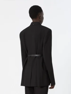 Back view of a person wearing a black tailored blazer with a belt, standing against a light background.