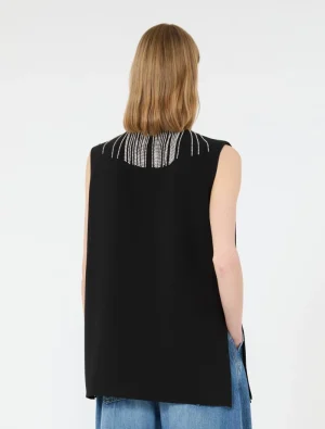 Back view of a person in a black sleeveless top with silver beaded fringe at the neckline, paired with blue jeans.
