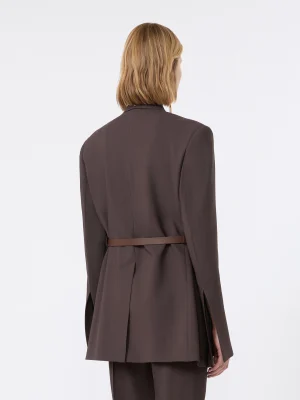 Person shown from behind wearing a dark brown blazer with a thin brown belt and matching pants; light brown hair visible over the collar