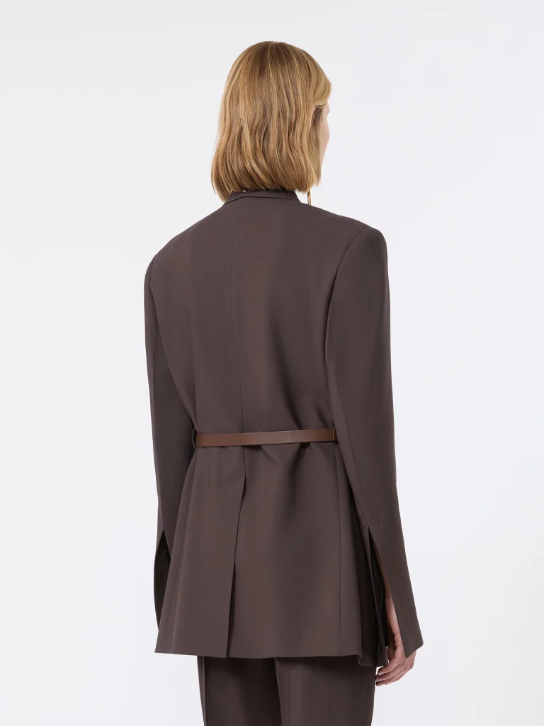 Person shown from behind wearing a dark brown blazer with a thin brown belt and matching pants; light brown hair visible over the collar
