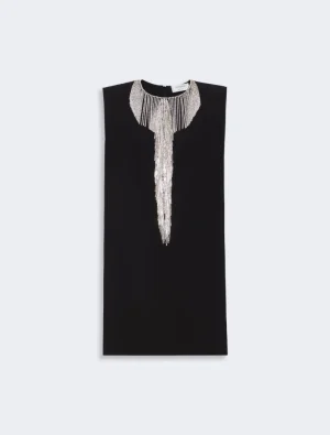 Black sleeveless shift dress with an elaborate silver bead collar and pearl-fringe pendant down the front.